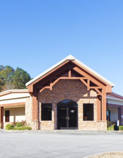 A single-story commercial building with a drive-thru under a clear blue sky.